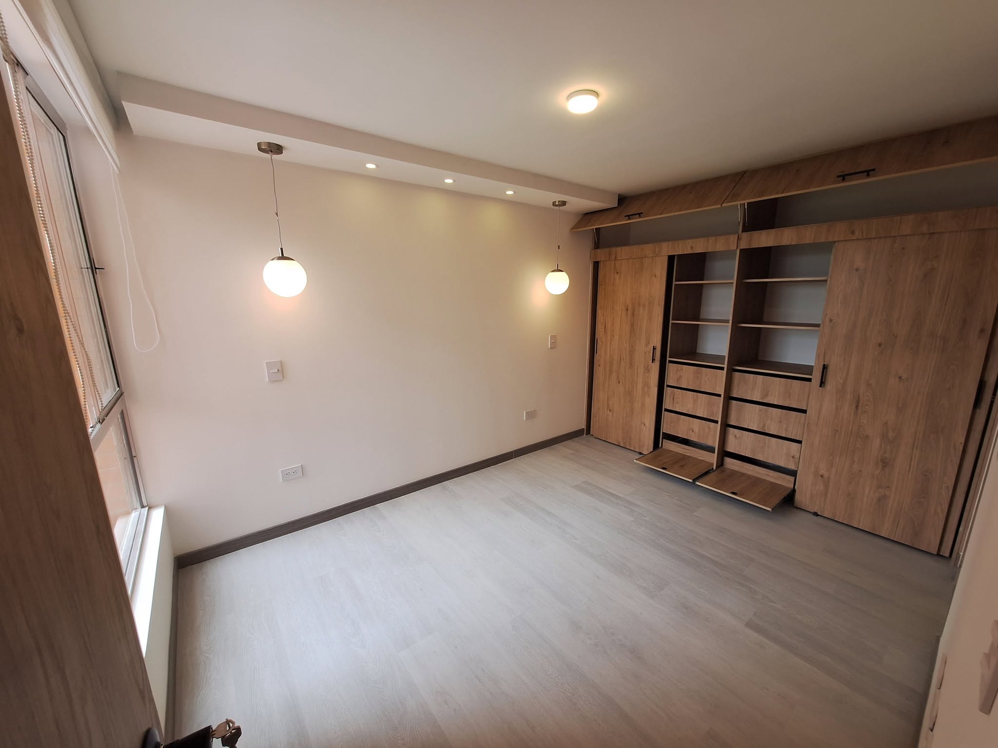 Closet a medida en madera con puertas corredizas y entrepaños