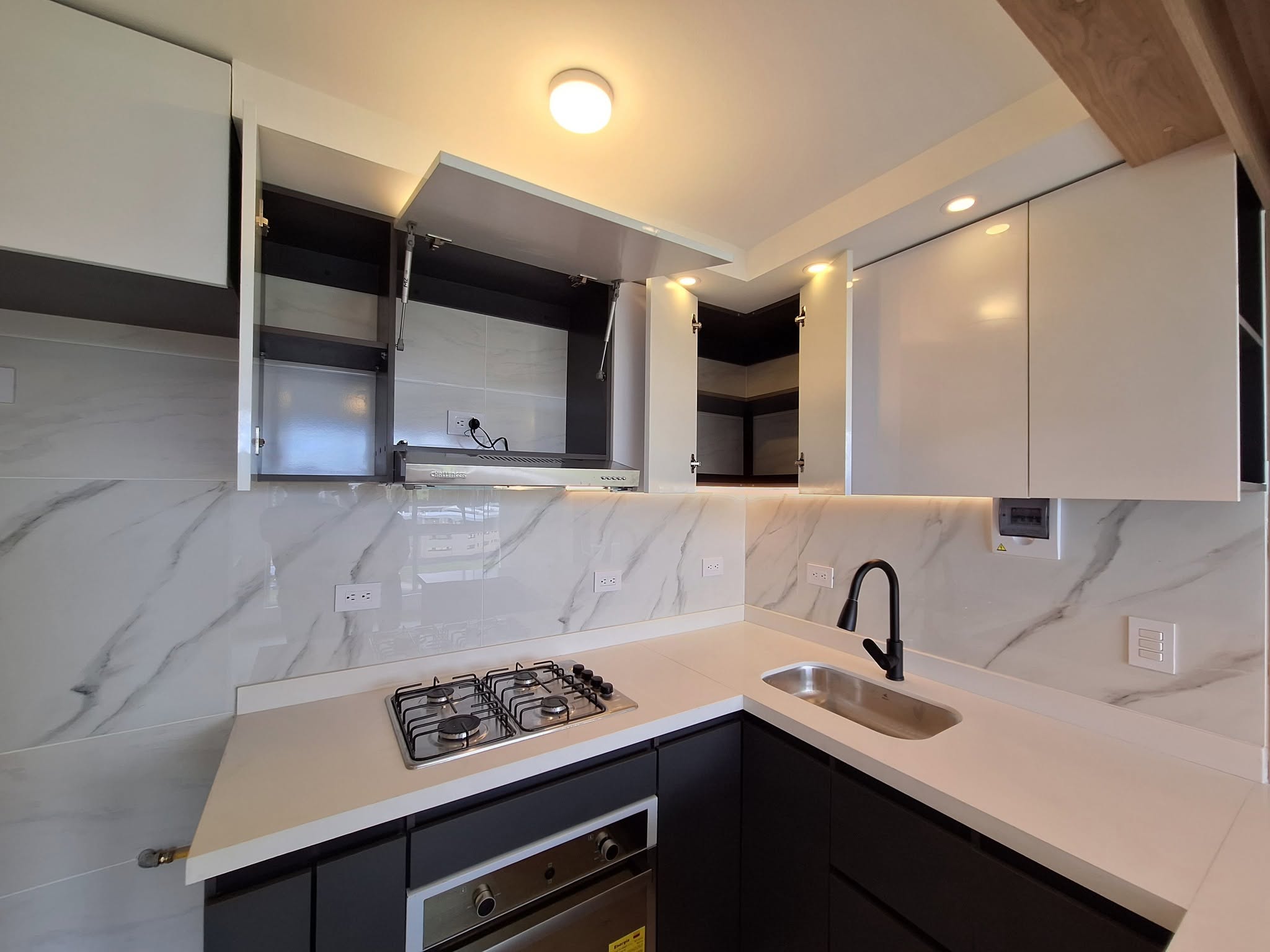 Cocina blanca con salpicadero en porcelanato tipo mármol